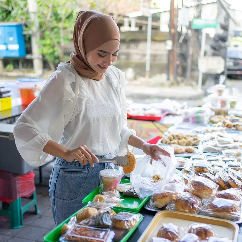 girl-veil-uses-tongs-pick-up-takjil-food copy